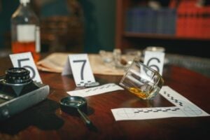 Crime scene, evidence with numbers on the table closeup, nobody. Detective investigation concept, magnifying glass and retro photo camera, vintage style room interior on background
